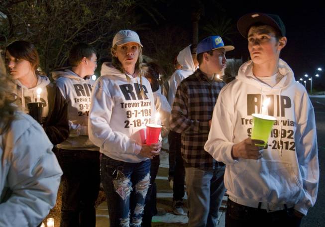 Jen Marquardt, left, and Richie Peterson wear sweatshirts in honor of Trevor Zarvian, 19, during a vigil for Zarvian and and Johnny Castiblanco, 19, at Windmill Parkway and Thayer Avenue in Henderson Sunday, Feb.19, 2012.  The pair died in an auto accident at the site Saturday. Also killed was an 86-year-old man. STEVE MARCUS